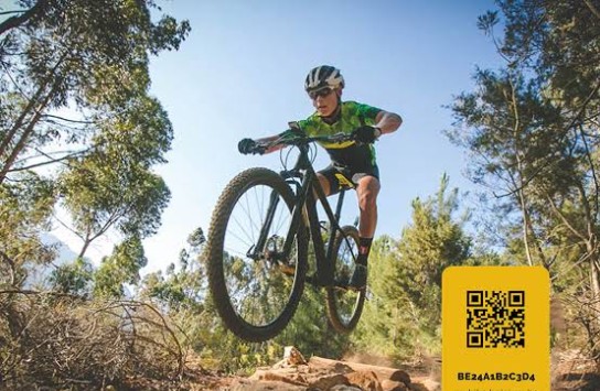 Jonge mountainbiker springt over rotsen in bos; promotie voor gratis fietsregistratie tegen diefstal. (vergroot foto)
